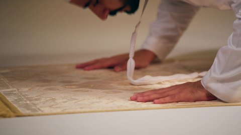 الحفاظ على إقامة الصلوات الخمس بوقتها، الإجتهاد في العبادة، شاب عربي خليجي اماراتي يرتدي الثوب الأبيض والطاقية يجلس على سجاده الصلاه يقوم بأداء فريضة الصلاة،الشعور بالخشوع والطمأنينة  ، مفهوم أركان الاسلام والأيمان،اجواء روحانية رمضانية، التقرب الى الله