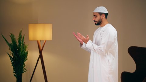 التقرب الى الله ، الحفاظ على إقامة الصلوات الخمس بوقتها، مفهوم أركان الاسلام والأيمان،الإجتهاد في العبادة، شاب عربي خليجي اماراتي يرتدي الثوب الأبيض والطاقية يقوم بأداء فريضة الصلاة، الشعور بالخشوع والطمأنينة
