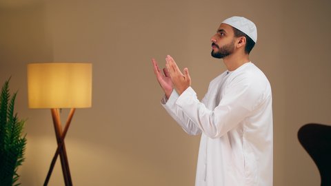 شاب عربي خليجي اماراتي يرتدي الثوب الأبيض والطاقية يقوم بأداء فريضة الصلاة، مفهوم أركان الاسلام والأيمان، التقرب الى الله ، الحفاظ على إقامة الصلوات الخمس بوقتها، الإجتهاد في العبادة،الشعور بالخشوع والطمأنينة