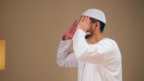 الحفاظ على إقامة الصلوات الخمس بوقتها، الإجتهاد في العبادة، مفهوم أركان الاسلام والأيمان، التقرب الى الله ،تصوير مقرب لشاب عربي خليجي اماراتي يرتدي الثوب الأبيض والطاقية يقوم بأداء فريضة الصلاة، الشعور بالخشوع والطمأنينة