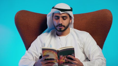 الاهتمام بتصفح الكتب المفيدة، تمضية أوقات الفراغ بالتعلم والتثقف الذاتي, إيماءات الانتباه والتركيز ,  رجل عربي خليجي اماراتي يرتدي الكندورة والغترة يقوم بالقراءة بتمعن, مطالعة القصص التصويرية المسلية, تنمية مهارات القراءة