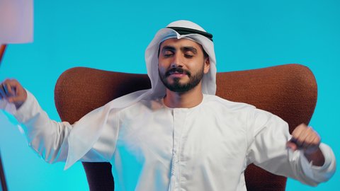 الحاجة إلى النوم والشعور بالتعب و الخمول, تعابير التأمل والتفكير، رجل عربي خليجي اماراتي يرتدي الكندورة والغتره يجلس على كرسي مريح يضع يديه خلف راسه بإيماءات الراحة والإسترخاء