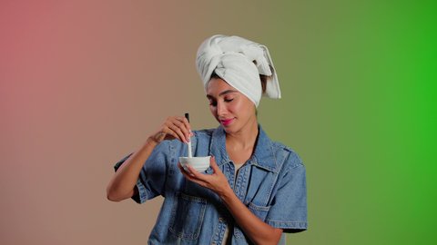 استخدام وصفات طبيعية للعناية بالبشرة، بورتريه لمرأة عربية خليجية سعودية تضع منشفة الرأس تمسك ماسك العسل بيديها ، مفهوم العناية والإهتمام بنضارة وتحسين البشرة ، خلفية ملونه