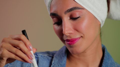 علاجات تجميل طبيعية، بورتريه مقرب لمرأة عربية خليجية سعودية تضع منشفة الرأس تمسك ماسك العسل بيديها ، مفهوم العناية والإهتمام بنضارة وتحسين البشرة  ، إستخدام مكونات تجميلية طبيعية ، خلفية ملونه