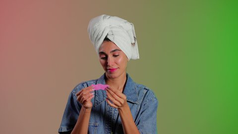 تنظيف وتقشير البشرة خلال الجلسات المتخصصة، ماسك تنظيف المسام، بورتريه مقرب لمرأة عربية خليجية سعودية ترتدي منشفة الرأِس تضع لصقات الأنف للتخلص من الرؤوس السوداء والجلد الميت ، خلفية ملونه