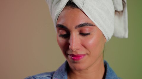 جلسات ترطيب وتجديد خلايا البشرة، ماسك تنظيف المسام، بورتريه مقرب لمرأة عربية خليجية سعودية ترتدي منشفة الرأِس تضع لصقات الأنف للتخلص من الرؤوس السوداء والجلد الميت ، خلفية ملونه