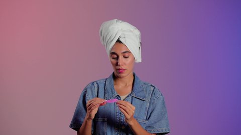 العناية الدورية بالبشرة للحفاظ على نضارتها، ماسك تنظيف المسام، بورتريه مقرب لمرأة عربية خليجية سعودية ترتدي منشفة الرأِس تضع لصقات الأنف للتخلص من الرؤوس السوداء والجلد الميت ، خلفية ملونه