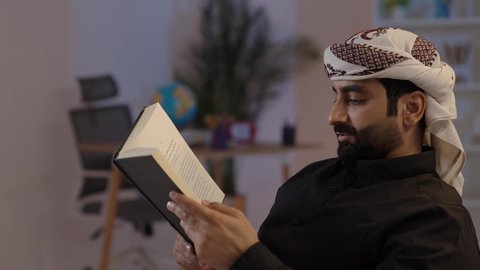 رجل عربي يمني يرتدي القميص والازار مع العمامة يجلس ويحمل كتاب، حب المطالعة و الاستكشاف، مفهوم الهيبة والاناقة، الاهتمام بتصفح الكتب المفيدة, اشغال النفس بالقراءة والتثقيف، مفهوم التأمل والتفكير، تمثيل الرجولة العربية الأصيلة،  المحافظة على اللباس التقليدي