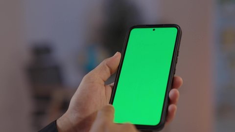 تصوير مقرب لايدي رجل عربي يمني يرتدي القميص والازار مع العمامة والجنبية يقف ويحمل هاتف، عرض خلفية شاشة خضراء، مفهوم لغة الجسد وتعابيرالوجه، تمثيل الرجولة العربية الأصيلة، الاجهزة التقنية الحديثة في الحياة اليومية،  مفهوم الهيبة والاناقة، خلفية بيج