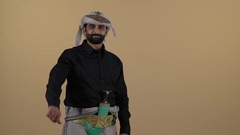 تصوير مقرب لرجل  عربي يمني مبتسم يرتدي القميص الازار مع العمامة  والجنبية يقوم بخفض اصبع الابهام للاسفل،عدم القبول والموافقة، اشارة غير مقبول، مفهوم العلاقات الاجتماعية،  المحافظة على اللباس التقليدي، مفهوم الهيبة والرجولة، خلفية بيج