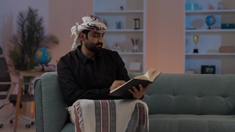 رجل عربي يمني يرتدي القميص والازار مع العمامة يجلس ويحمل كتاب، قضاء وقت الفراغ بالقراءة، مفهوم التأمل والتفكير، الاهتمام بتصفح الكتب المفيدة, تمثيل الرجولة العربية الأصيلة، المطالعة والاهتمام بالكتب القديمة،  مفهوم الهيبة والاناقة، المحافظة على اللباس التقليدي