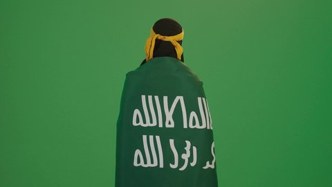 التباهي بإنجازات البلاد, بورتريه من الخلف لامرأة عربية خليجية سعودية مبتسمة ترتدي الشيلة والنشل تضع على كتفيها علم المملكة, يوم تأسيس الدولة السعودية الأولى 1727 م، ارتداء أزياء المنطقة الشرقية، يوم بدينا 22 فبراير، الاحتفال بالأعياد الوطنية, خلفية خضراء، كروما