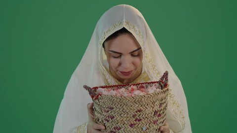 المناسبات والأعياد الوطنية، ذكرى تأسيس الدولة السعودية الاولى 22 فبراير، بورتريه لشابة عربية خليجية سعودية ترتدي الثوب الابيض المطرز بالذهبي وتضع الشيله على رأسها تحمل بيدها سلة من القش ممتلئة بالورد الجوري الطبيعي، الزي السعودي التقليدي الشعبي ، كروما ، خلفية خضراء