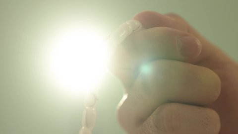 The abundance of mentioning Allah Almighty, seeking forgiveness, and supplication, the concept of striving in worship and drawing closer to Allah, a close-up image of the hands of a young Arab Saudi Gulf boy raising his hands holding a prayer bead.