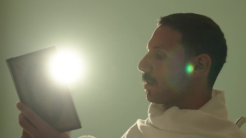 التمعن بسور القرآن الكريم, مفهوم العبادة والطاعة والتقرب الى الله في شهر رمضان المبارك, تدبر الآيات القرآنية والتفكر بها، رجل عربي خليجي سعودي يرتدي لباس الاحرام يقرأ من المصحف الشريف