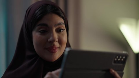 الدردشة مع الأهل والأصدقاء، استخدام تطبيقات وبرامج الأجهزة اللوحية،دمج التكنولوجيا والتقنيات الحديثة فى الحياه اليوميه ، امراه عربيه خليجيه عمانيه ترتدي العباءه والحجاب تحمل بيدها جهاز التابلت، تصفح مواقع التواصل الاجتماعي