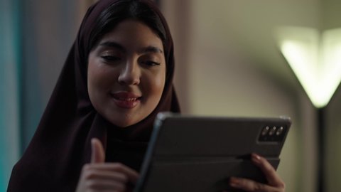 استخدام تطبيقات وبرامج الأجهزة اللوحية، الدردشة مع الأهل والأصدقاء، دمج التكنولوجيا والتقنيات الحديثة فى الحياه اليوميه ، امراه عربيه خليجيه عمانيه ترتدي العباءه والحجاب تحمل بيدها جهاز التابلت، تصفح مواقع التواصل الاجتماعي