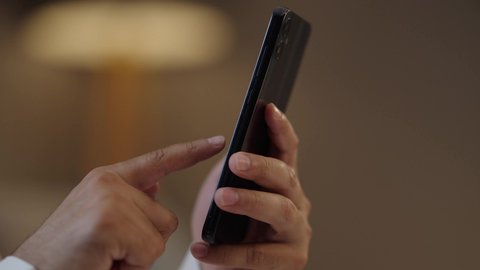 الدردشة والتحدث مع الاصدقاء عبر الانترنت، تصوير مقرب لرجل عربي خليجي سعودي  يقوم بمتابعة اخبار وسائل التواصل الاجتماعي باستخدام الجوال، تصفح تطبيقات الهاتف المحمول، استخدام جهاز تقني حديث ومتطور