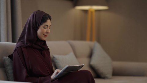 ايماءات السعادة و السرور، التعبير عن الألفة والمحبة بين الزوجين، إحياء ذكرى يوم الزواج، رجل عربي خليجي سعودي يرتدي الثوب الابيض يقدم لزوجته هديه في علبة بمناسبة عيد الحب، تصفح مواقع التواصل الاجتماعي عبر التابلت