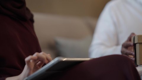 التعبير عن الألفة والمحبة بين الزوجين، إحياء ذكرى يوم الزواج، تصوير مقرب لرجل عربي خليجي سعودي يقدم لزوجته هديه في علبة بمناسبة عيد الحب، تصفح مواقع التواصل الاجتماعي عبر التابلت