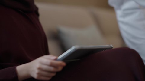 التعبير عن الألفة والمحبة بين الزوجين، إحياء ذكرى يوم الزواج، تصوير مقرب لرجل عربي خليجي سعودي يقدم لزوجته هديه في علبة بمناسبة عيد الحب، تصفح مواقع التواصل الاجتماعي عبر التابلت