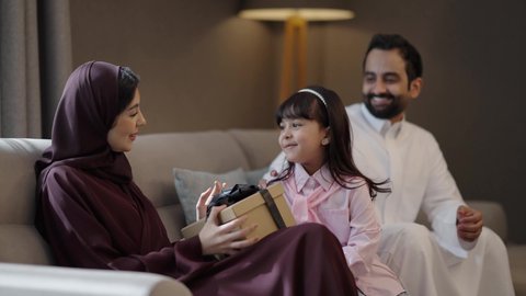 قضاء الأوقات الممتعه مع الأبناء، التربيه الصالحة وإنشاء الأطفال على الحب والعطاء، فتاة عربيه خليجيه سعودية تحتفل بعيد الأم وتقدم لوالدتها الهدية، ايماءات تدل على الفرح و السعادة، الإحتفال سويا في الأعياد والمناسبات