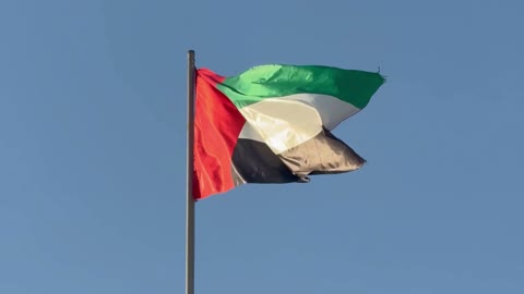 Love for the homeland and belonging to it, pride and honor in the national identity, celebrating the UAE National Day, a display of a drone carrying the flag of the United Arab Emirates fluttering in the air in the blue sky, the national symbol of the United Arab Emirates, the United Arab Emirates.