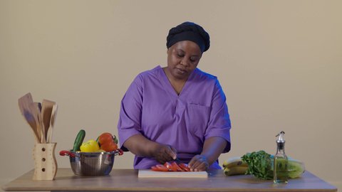 تحضير الوجبات للطهي، غذاء مفيد وصحي، بورتريه لعاملة فلبينية ترتدي اليونيفورم الخاص تقف في المطبخ تقوم بتقطيع الخضار, مفهوم النظام الغذائي، وصفات الطعام الشهية، خلفية بنية