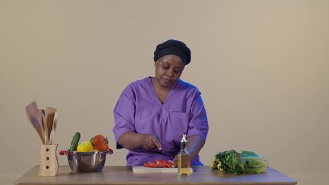 Expressions of gratitude and appreciation for the quality of service and performance of the domestic worker, preparing and organizing the necessary ingredients, preparing vegetables in the kitchen, a foreign worker wearing the special uniform is cutting vegetables alongside the housewife, employing licensed and qualified workers from Saudi companies and offices.