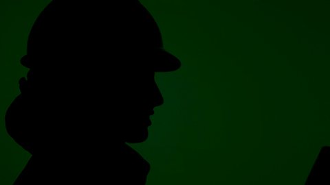 التدقيق والإشراف على المشاريع الهندسية في موقع العمل, التصاميم المعمارية وتدقيق المخططات , تصوير ظلى لمهندسة عربية خليجية سعودية ترتدي سترة الحماية و الخوذة  تمسك بيدها مخططات هندسية وتقف بإيماءات الثقة والفخر