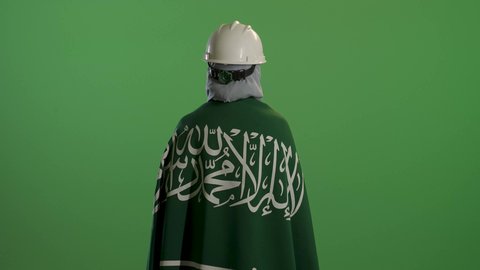 بورتريه من الخلف لمهندسة عربية خليجية سعودية ترتدي سترة الحماية والخوذة تضع على كتفيها علم المملكة, التباهي بإنجازات البلاد, اليوم الوطني السعودي 23 سبتمبر, يوم العلم 11 مارس, خلفية خضراء, كروما