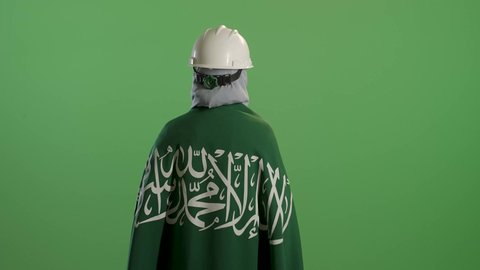 يوم بدينا 1727 م، ذكرى تأسيس الدولة السعودية الأولى 22 فبراير, بورتريه من الخلف لمهندسة عربية خليجية سعودية ترتدي سترة الحماية والخوذة تضع على كتفيها علم المملكة, التباهي بإنجازات البلاد, خلفية خضراء, كروما