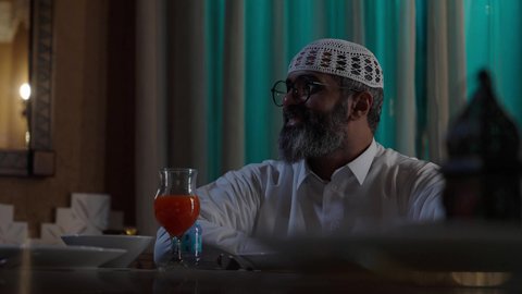 إحضار الطبق الرئيسي ووضعه على السفرة، أداء فريضة الصيام في شهر رمضان المبارك، قضاء أوقات ممتعه مع الأهل والأبناء، تبادل الأحاديث بين أفراد الأسرة، طفل عربي خليجي سعودي مجتمع مع عائلته حول مائدة الطعام، سفرة مليئة بأصناف من المأكولات الشرقية الشهية