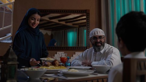 الشكر والامتنان للأم على الطعام , أداء فريضة الصيام في شهر رمضان المبارك، قضاء أوقات ممتعه مع الأهل والأبناء، تبادل الأحاديث بين أفراد الأسرة، طفل عربي خليجي سعودي مجتمع مع عائلته حول مائدة الطعام، سفرة مليئة بأصناف من المأكولات الشرقية الشهية