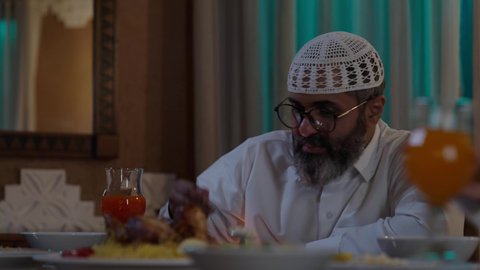 تقديم النصائح الأبوية للاطفال, أداء فريضة الصيام في شهر رمضان المبارك، قضاء أوقات ممتعه مع الأهل والأبناء، تبادل الأحاديث بين أفراد الأسرة، طفل عربي خليجي سعودي مجتمع مع عائلته حول مائدة الطعام، سفرة مليئة بأصناف من المأكولات الشرقية الشهية