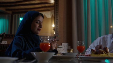 أجواء عائلية روحانية دينية إسلامية,  أداء فريضة الصيام في شهر رمضان المبارك، قضاء أوقات ممتعه مع الأهل والأبناء، تبادل الأحاديث بين أفراد الأسرة، طفل عربي خليجي سعودي مجتمع مع عائلته حول مائدة الطعام، سفرة مليئة بأصناف من المأكولات الشرقية الشهية