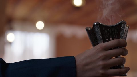 الاهتمام بالمظهر الخارجي،  جمال النساء السعوديات، مفهوم الأنوثة والأناقة والشياكة والنعومة، أزياء محجبات عصرية حديثة، تصوير مقرب لامرأة عربيه خليجيه سعودية محجبه ترتدي الحجاب والعباءة تقوم بتعطير نفسها باستخدام حامل البخور، روائح وعطور خليجية مميزة