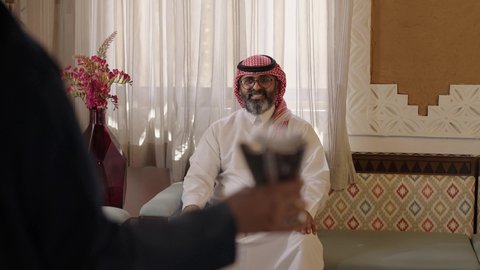 الاصالة والعراقة والتراث السعودي, عطورات وروائح خليجية مميزة، تصوير لإمراة عربية خليجية سعودية ترتدي العباءة والحجاب تقوم بتبخير وتعطير والده الكبير بالعمر بالمبخرة، التبخر والتطيب بخشب العود، عادات وتقاليد المجتمع السعودي في الأعياد والمناسبات الاسلامية