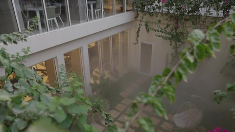 أجواء هادئة وطبيعة محيطة، مبنى سكني عصري محاط بأشجار خضراء ونباتات طبيعية، تصميم معماري حديث