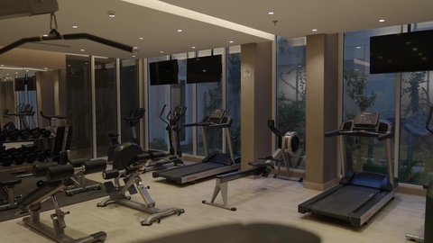 تدريبات عضلات ولياقة داخل صالة رياضية، معدات متنوعة ومساحة تدريب مريحة، مركز تدريب رياضي، صالة جيم مجهزة بأحدث الأجهزة