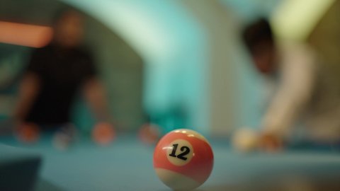 أنشطه وهوايات شبابيه، مفهوم المنافسات والتحديات، قضاء أوقات الفراغ مع الاصدقاء, طاولة بلياردو (السنوكر), تصوير مقرب لشابان عربيان خليجيان سعوديان يرتديان ملابس كاجوال والزي التقليدي يلعبان لعبة البلياردو، صاله رياضيه شبابيه