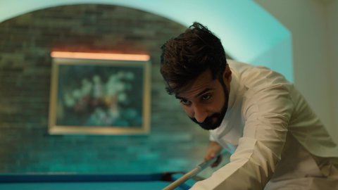 صاله رياضيه شبابيه، مفهوم المنافسات والتحديات، قضاء أوقات الفراغ ممتعة, أنشطه وهوايات شبابيه, طاولة بلياردو (السنوكر), شاب عربي خليجي سعودي يرتدي الثوب الابيض يقومب بممارسة لعبة البلياردو