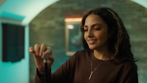 أنشطة وهوايات شبابية، التسلية والترفيه وقضاء الوقت الممتع, الاستمتاع والشغف بممارسة لعبة السنوكر, تصوير مقرب لشابة عربية خليجية سعودية ترتدي الزي الكاجوال  تمسك بيديها عصا لعب البلياردو