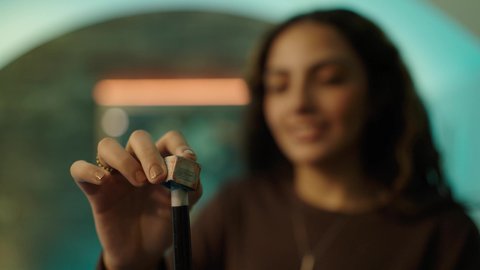 التسلية والترفيه وقضاء الوقت الممتع، أنشطة وهوايات شبابية, الاستمتاع والشغف بممارسة لعبة السنوكر, تصوير مقرب لشابة عربية خليجية سعودية ترتدي الزي الكاجوال  تمسك بيديها عصا لعب البلياردو