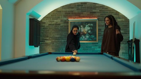 Competitive activities, challenges, and play, having fun with friends, a youth sports hall, youth activities and hobbies, billiard table (snooker), two Arab Gulf friends playing billiards.