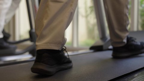 رياضات لتقوية العضلات ونحت الجسم، ، تحمل التمارين القاسية للمحافظة على اللياقة, وقت ممتع أثناء التمرين ، أسلوب حياة صحية، استخدام الأجهزة التقنية الحديثة، مفهوم حرق الدهون و إنقاص الوزن، تصوير مقرب لقدم شابان عربيان خليجيان سعوديان يرتديان الملابس الرياضية