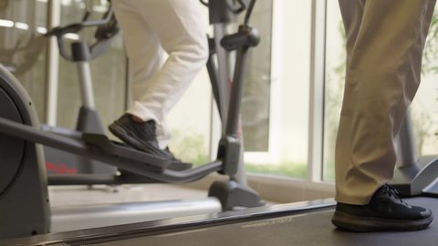 رياضات لتقوية العضلات ونحت الجسم، ، تحمل التمارين القاسية للمحافظة على اللياقة, وقت ممتع أثناء التمرين ، أسلوب حياة صحية، استخدام الأجهزة التقنية الحديثة، مفهوم حرق الدهون و إنقاص الوزن، تصوير مقرب لقدم شابان عربيان خليجيان سعوديان يرتديان الملابس الرياضية