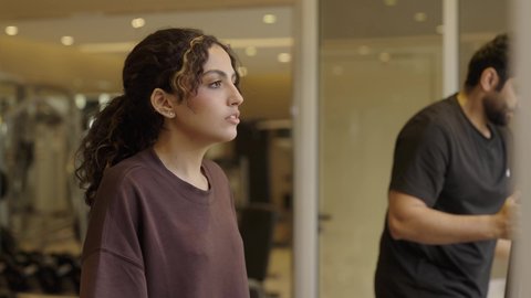 أهمية الرياضة لبناء جسد قوي، ممارسة الرياضة المفضلة مع الأصدقاء، قضاء وقت ممتع أثناء التمرين، الاهتمام بالصحة واللياقة الجسدية، بنت عربيه سعودية  تقوم بالتمرين لتحسين وضعية الجسم والتوازن، شاب عربي خليجي سعودي يرتدي الزي الرياضي يقوم بممارسة التمارين على جهاز المشي