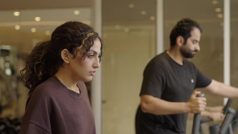 ممارسة الرياضة المفضلة مع الأصدقاء، قضاء وقت ممتع أثناء التمرين, أهمية الرياضة لبناء جسد قوي، الاهتمام بالصحة واللياقة الجسدية، بنت عربيه سعودية  تقوم بالتمرين لتحسين وضعية الجسم والتوازن، شاب عربي خليجي سعودي يرتدي الزي الرياضي يقوم بممارسة التمارين على جهاز المشي