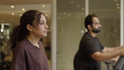 قضاء وقت ممتع أثناء التمرين, ممارسة الرياضات المفضلة مع الأصدقاء, أهمية الرياضة لبناء جسد قوي، الاهتمام بالصحة واللياقة الجسدية، بنت عربيه سعودية  تقوم بالتمرين لتحسين وضعية الجسم والتوازن، شاب عربي خليجي سعودي يرتدي الزي الرياضي يقوم بممارسة التمارين على جهاز المشي